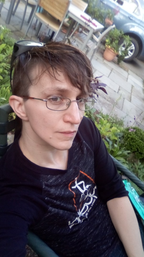 Asher sitting down with garden plants in the background.