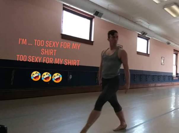 The author, striding towards audience left while staring over his left shoulder with both arms held straight down.